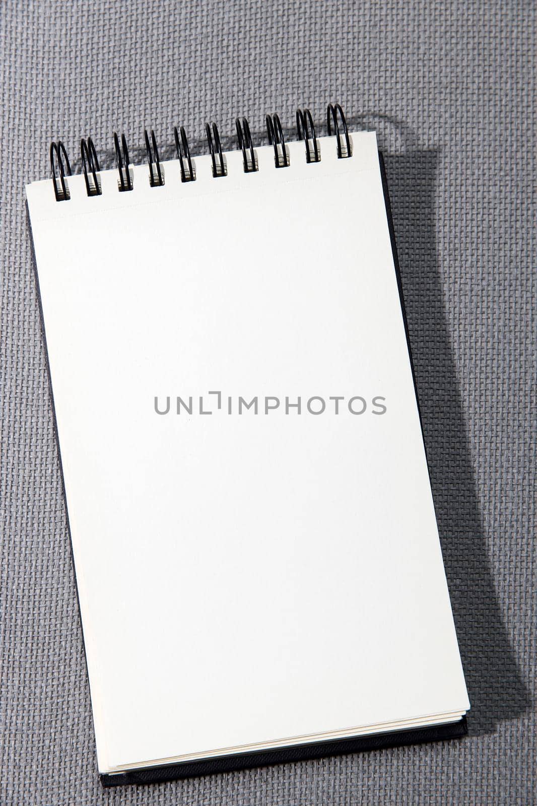 A white springboard for sketching is on a gray canvas texture. by elenarostunova