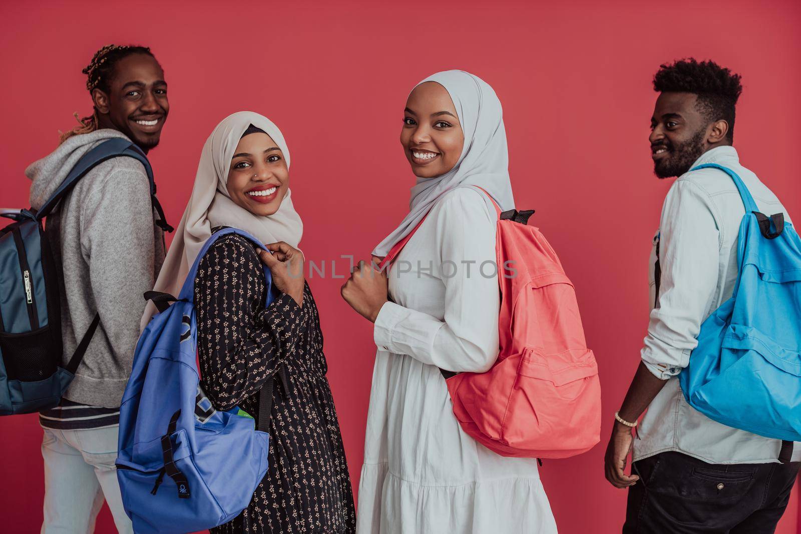 A group of African Muslim students with backpacks posing on a pink background. the concept of school education. High-quality photo
