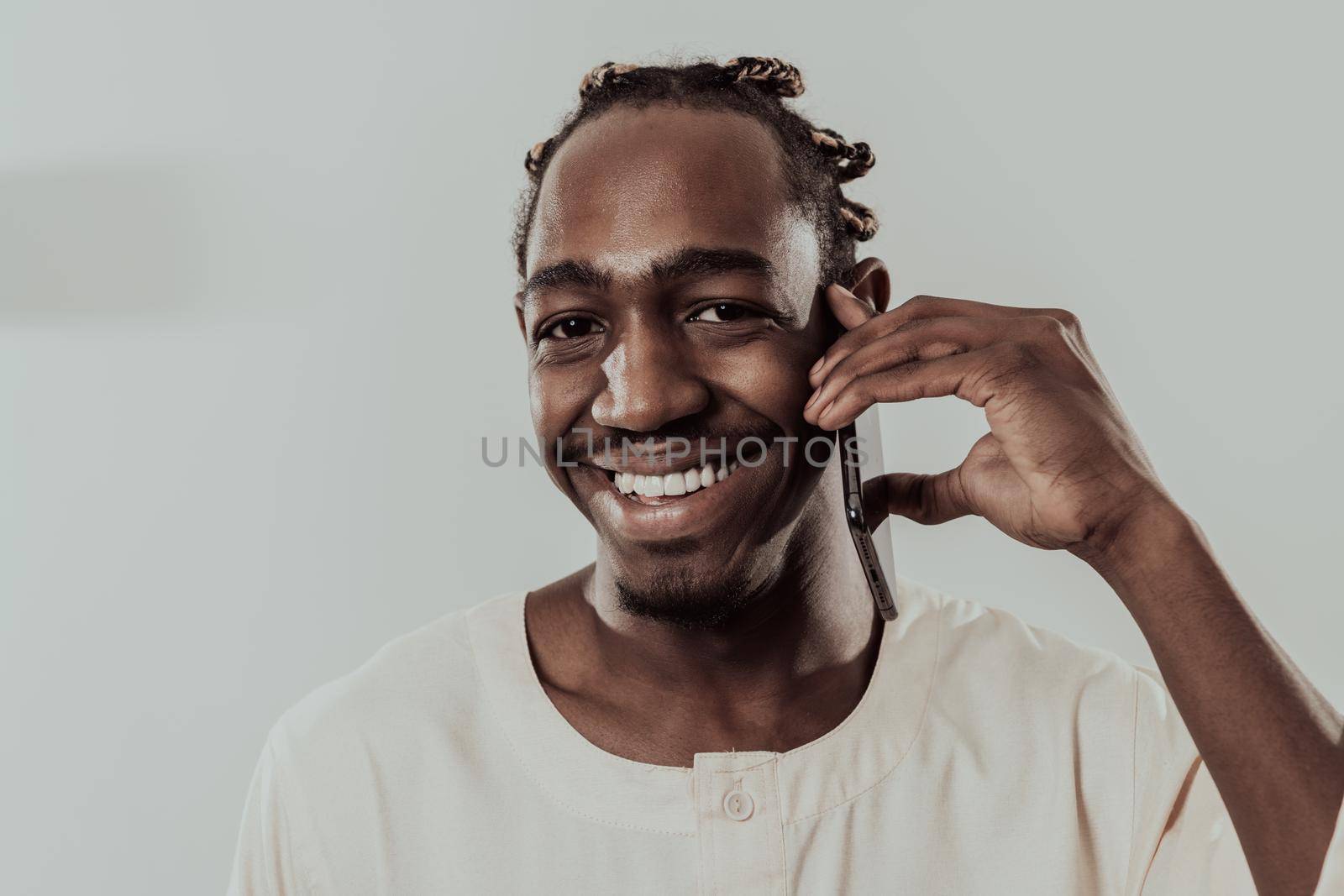 African man using smartphone and wearing traditional Sudan clothes. High-quality photo