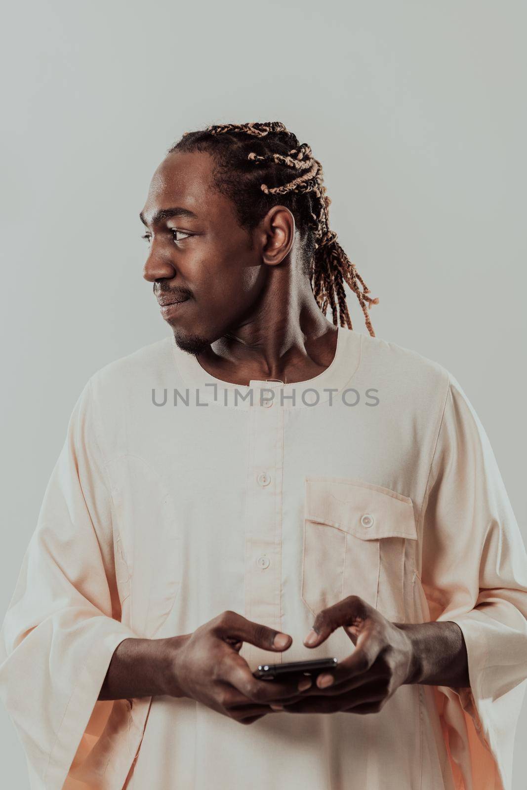African man using smartphone and wearing traditional Sudan clothes. High-quality photo