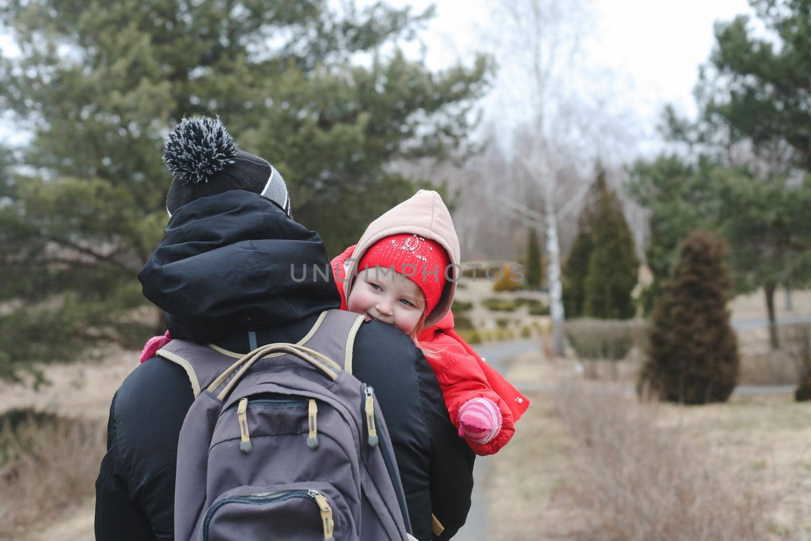 Little funny girl on dad's arms. Daughter hugs dad. Father holding daughter outdoors.