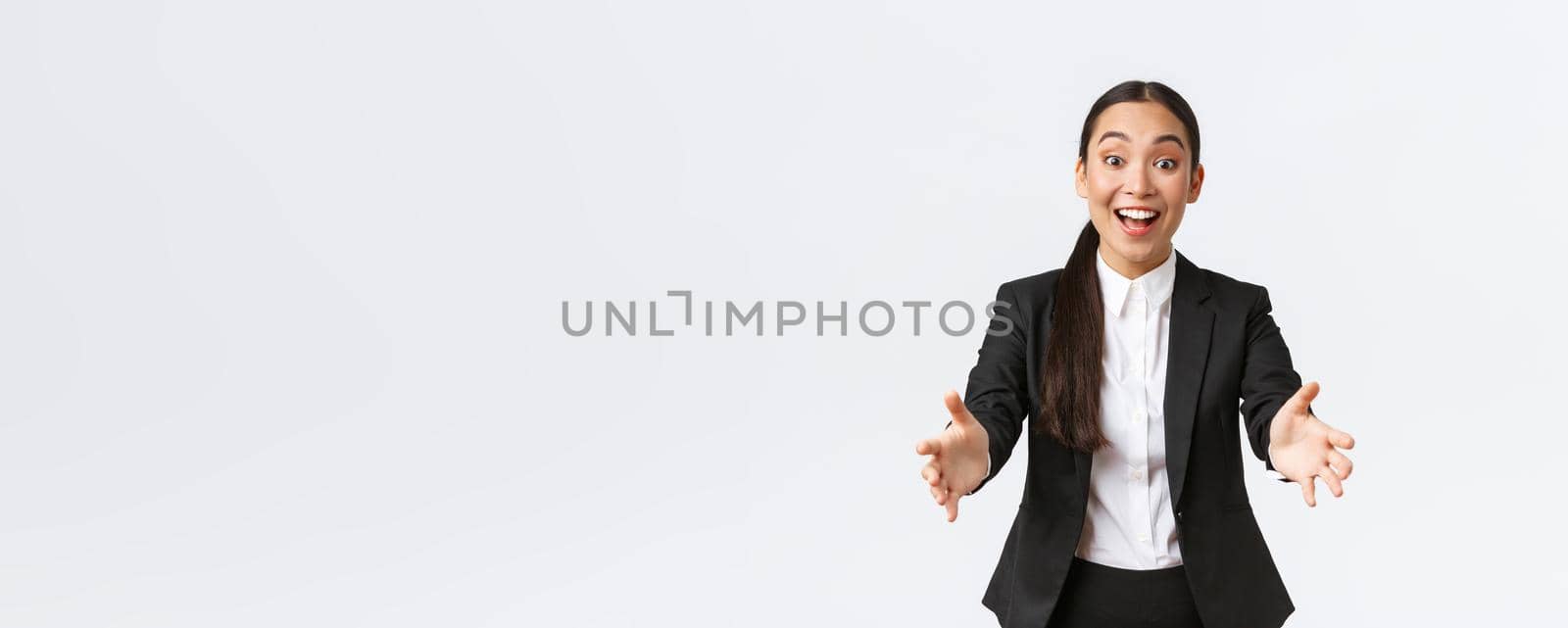Happy and excited asian female entrepreneur reaching hands forward to congratulate with amazing achievement coworker, leaning for hug or embraces, impressed with great deal, white background.
