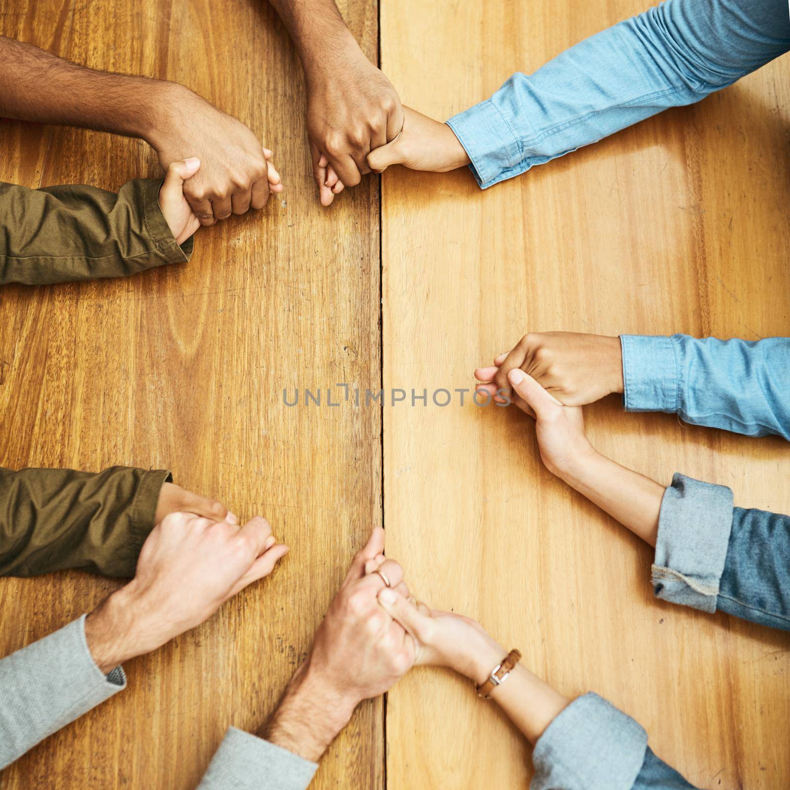 Seeking a little divine intervention. High angle shot of a group of unrecognizable university students praying for help with their upcoming exams. by YuriArcurs