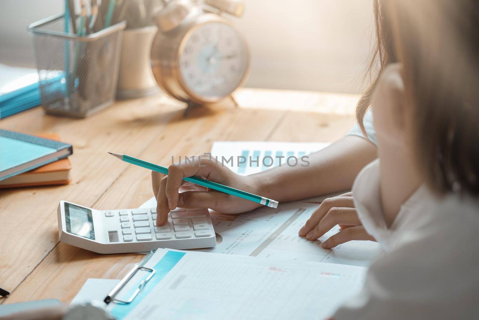 Close up of businessman or accountant working on calculator to calculate business data, accountancy document at meeting room.