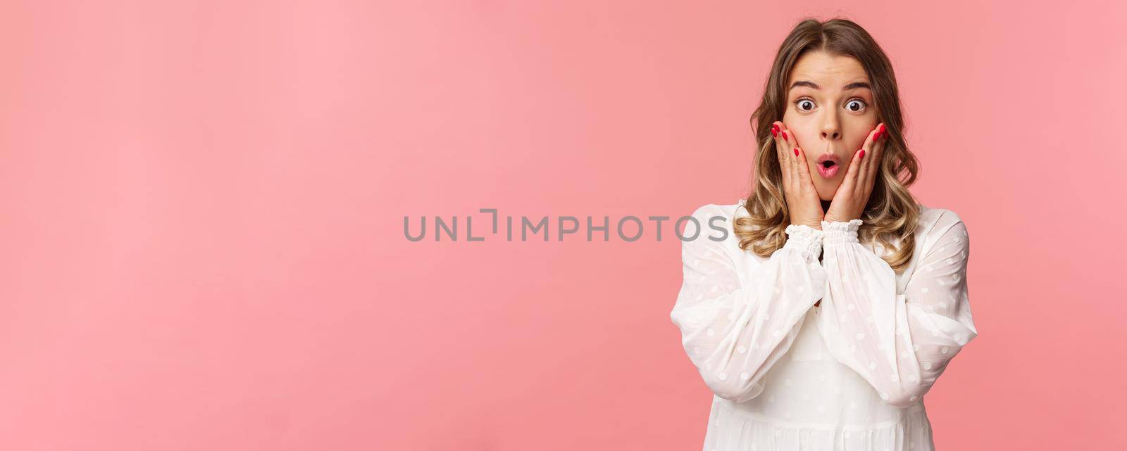 No way, what a story. Stunned and amazed blond girl listening to gossips with excitement and interest, hold hands on cheeks say wow and stare astonished camera, standing pink background by Benzoix