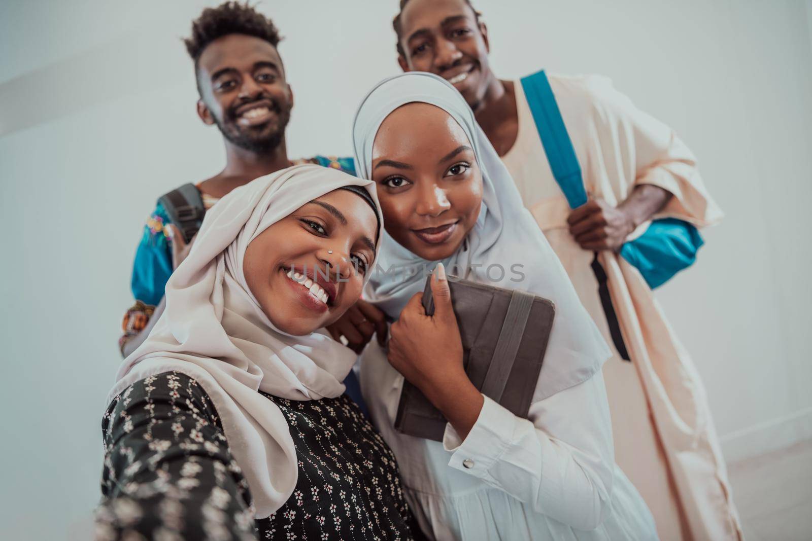 A group of multiethnic students take a selfie with a smartphone on a white background. Selective focus by dotshock