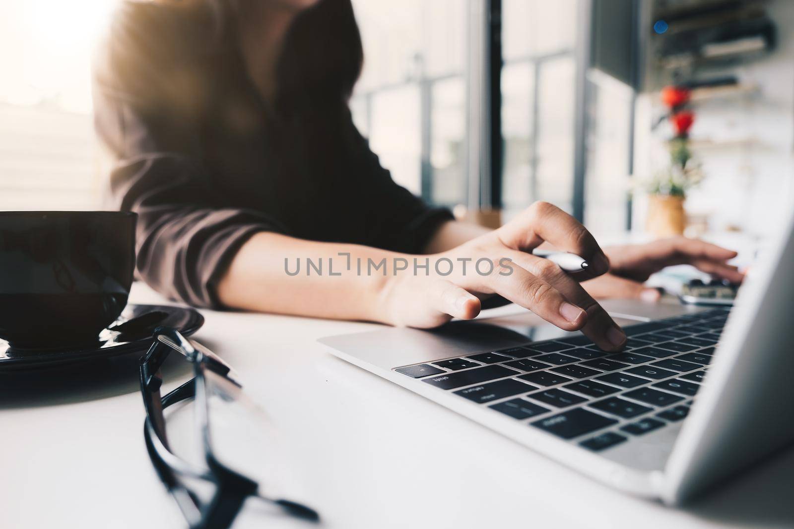 Close up, businesswoman or lawyer accountant working on accounts using a calculator and laptop computer in her office
