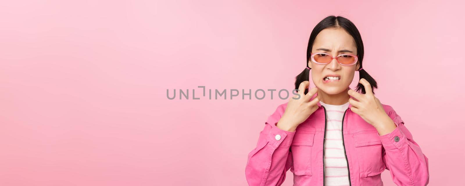 Image of angry, pissed off korean adult female model, shaking fists and shouting, screaming outraged, standing over pink background by Benzoix