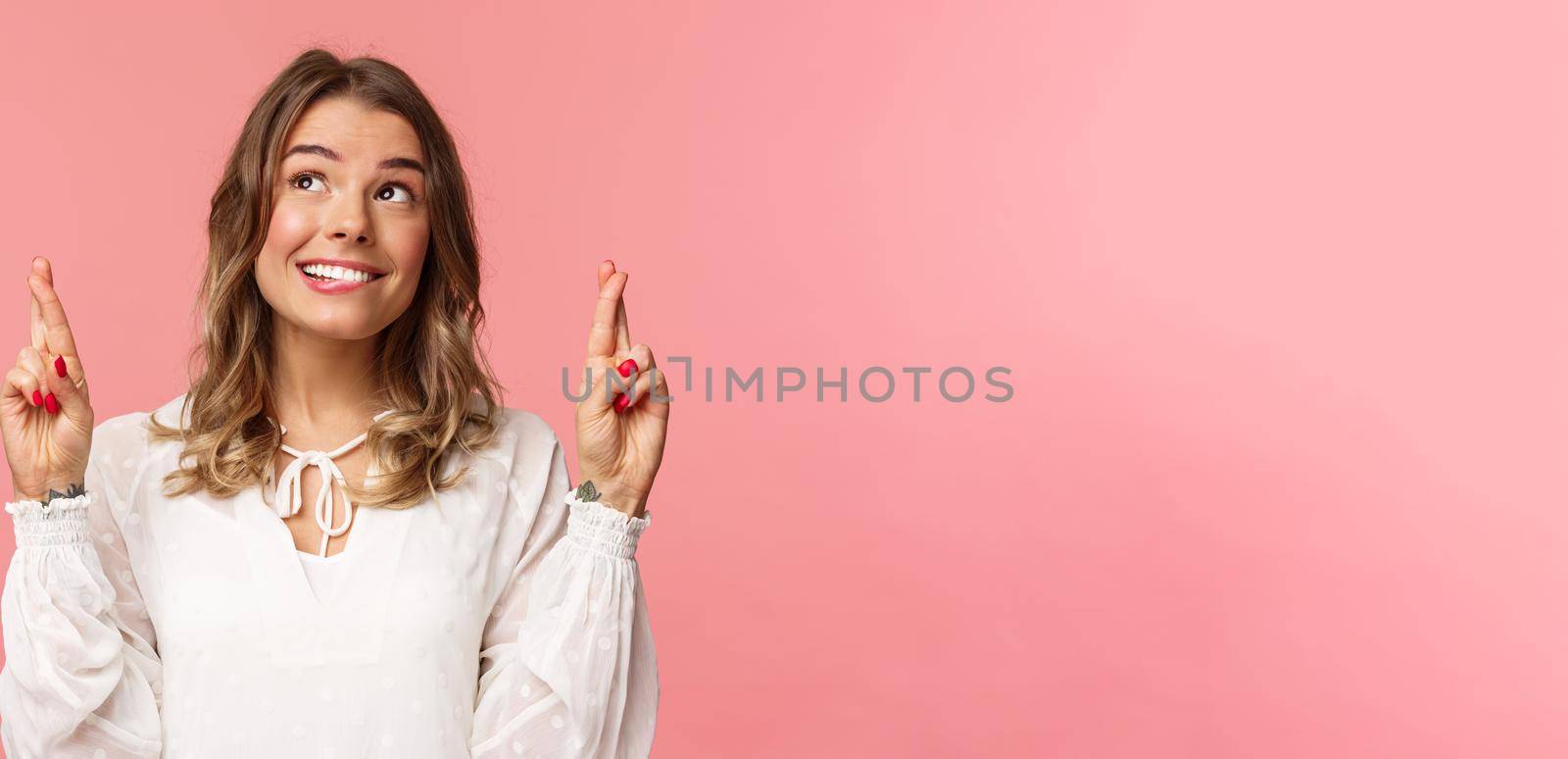 Close-up portrait of hopeful, optimistic attractive woman in white dress, bite lip and smiling as daydreaming, hope dream come true, making wish or praying, standing pink background by Benzoix