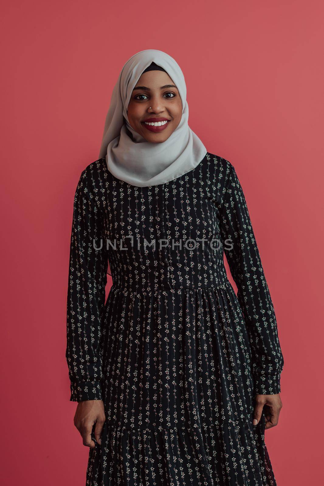 Portrait of young modern muslim afro beauty wearing traditional islamic clothes on plastic pink background. Selective focus. High quality photo