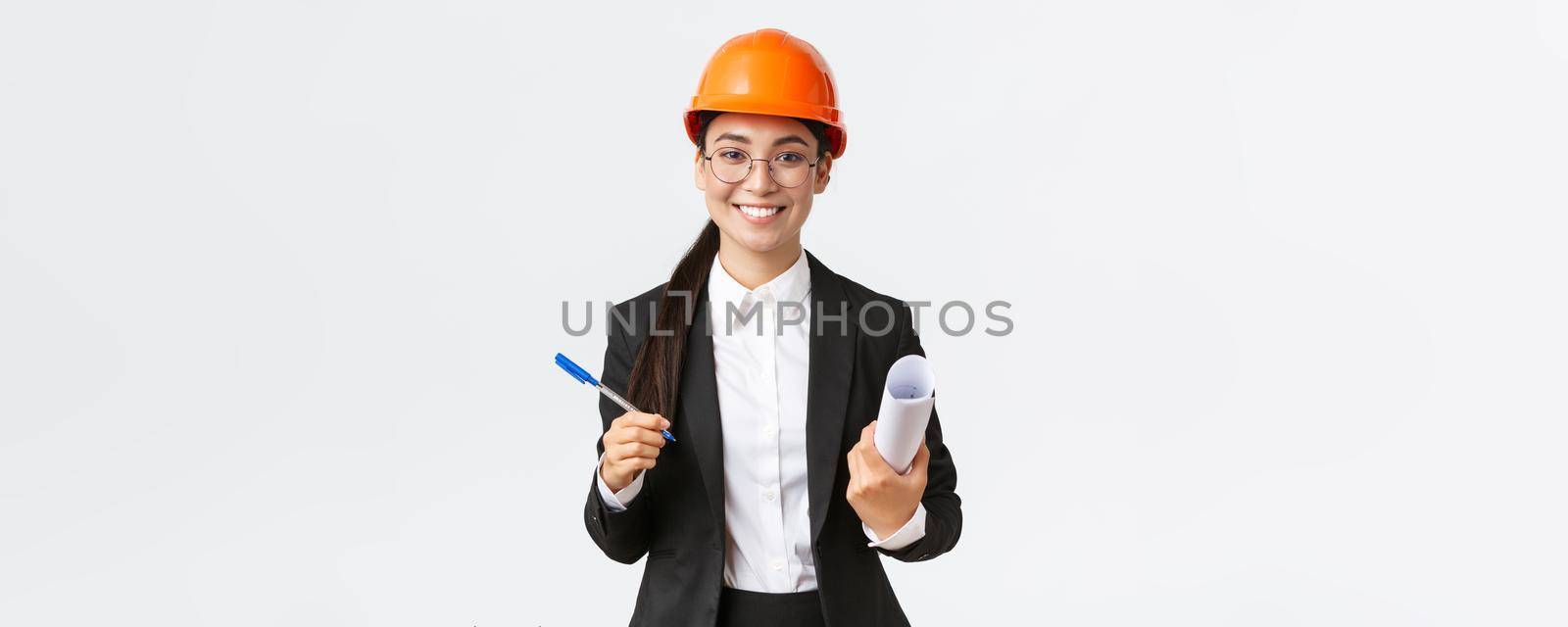 Smiling successful female entrepreneur, chief construction engineer in helmet and suit, holding blueprints and pen, signing contract with building supplier, white background by Benzoix