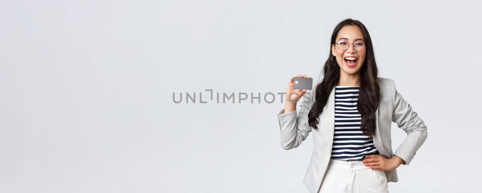 Business, finance and employment, entrepreneur and money concept. Laughing cheerful and outgoing female office manager in white suit and glasses showing credit card by Benzoix