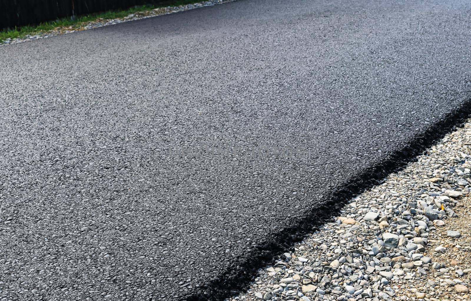 New layer of asphalt road under construction by vladispas
