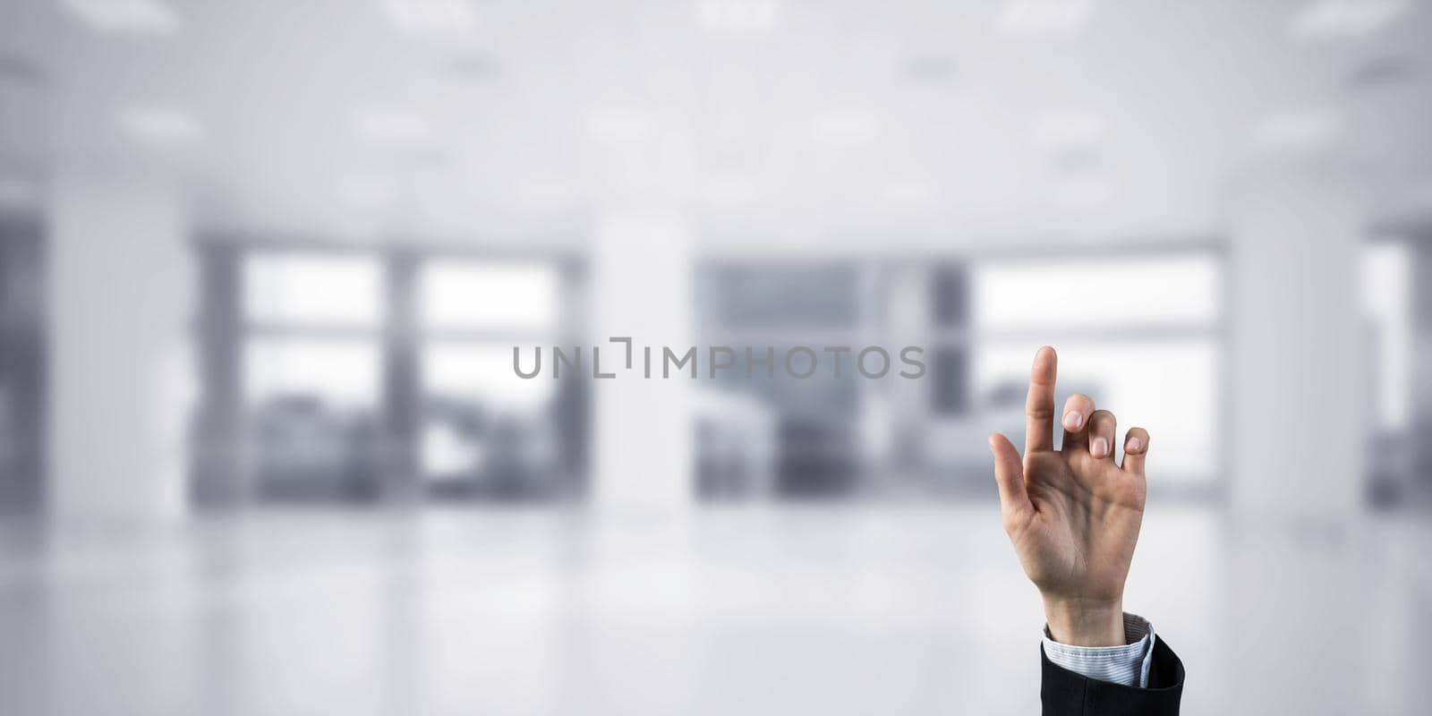 Close of businesswoman hand touching screen with finger and office at background