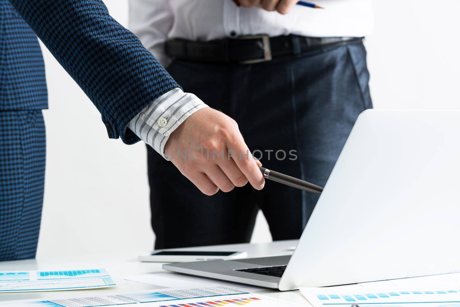 Business consultation and discussing with colleagues in office. Corporate teamwork and collaboration. Professional analysis of financial indexes. Businessman and businesswoman stand near desk