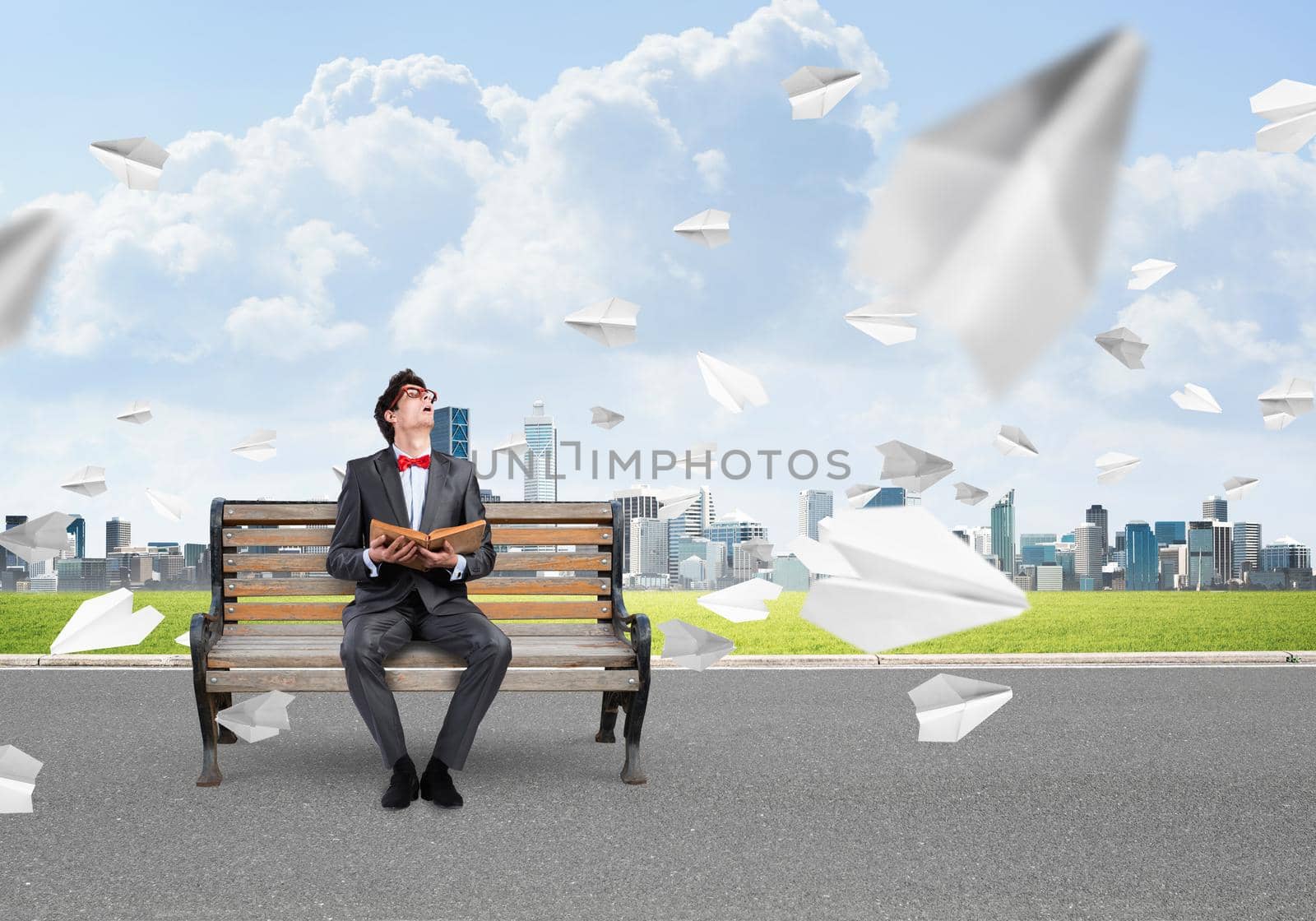 young businessman with a book. flying around paper plane in chaos