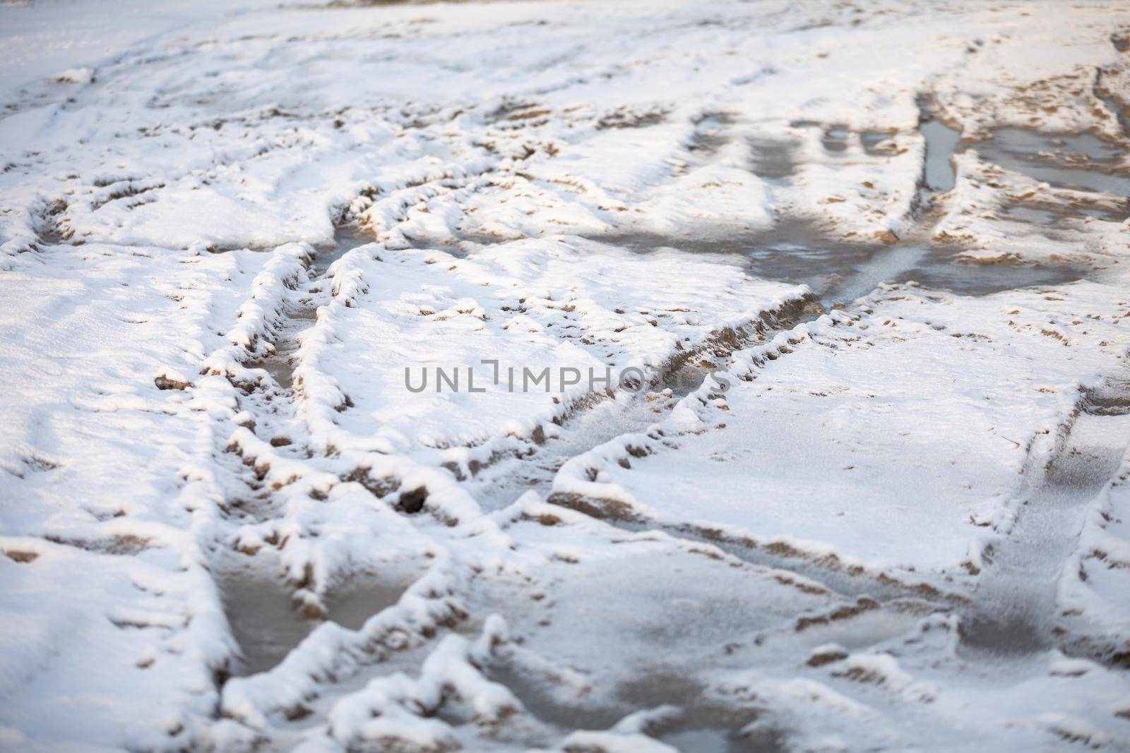 A country road full of car ruts covered with fresh snow. Winter aura on dirt roads outside the city.