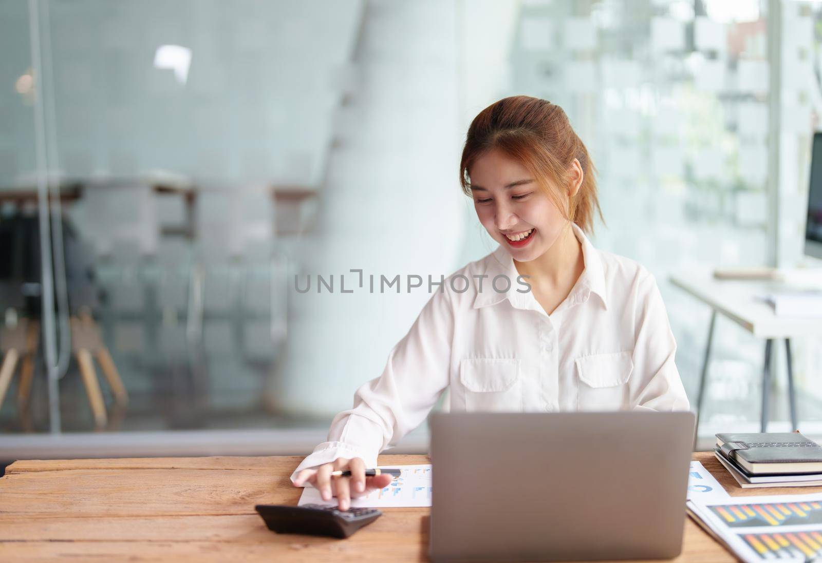 data analysis, marketing, accounting, auditing, portrait of business woman using marketing planning calculator using statistical data sheet, computer to present a marketing plan project at a meeting. by Manastrong