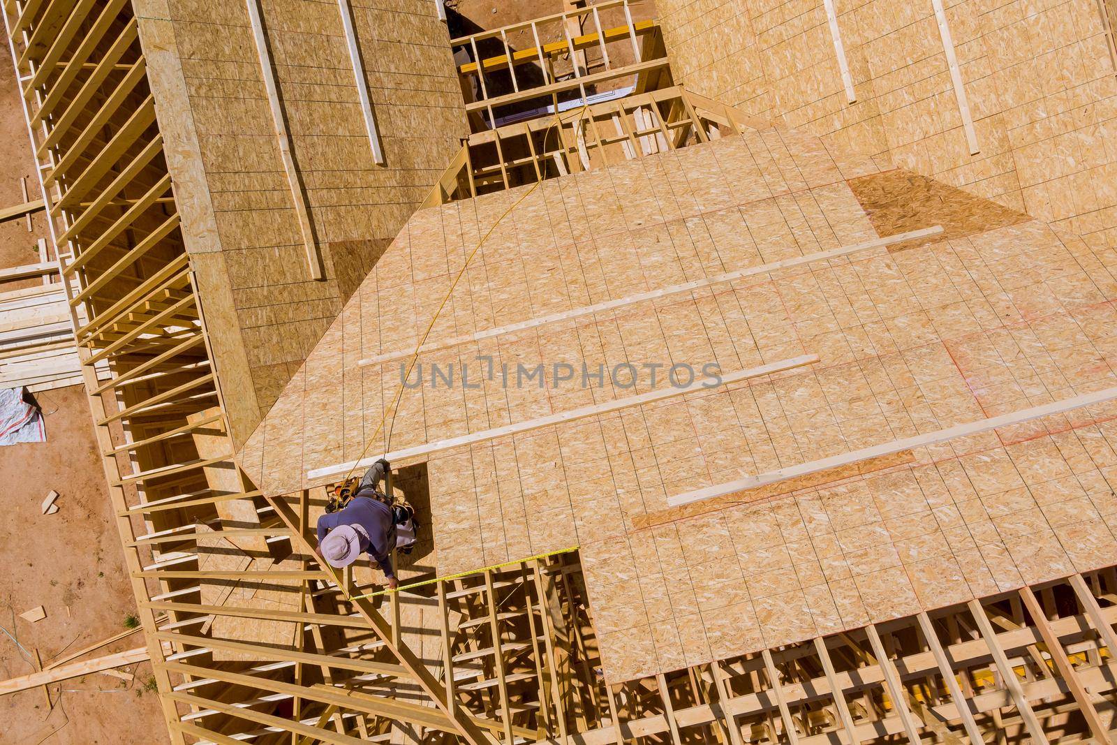 Builder on working a new roof in unfinished house with wood frame construction