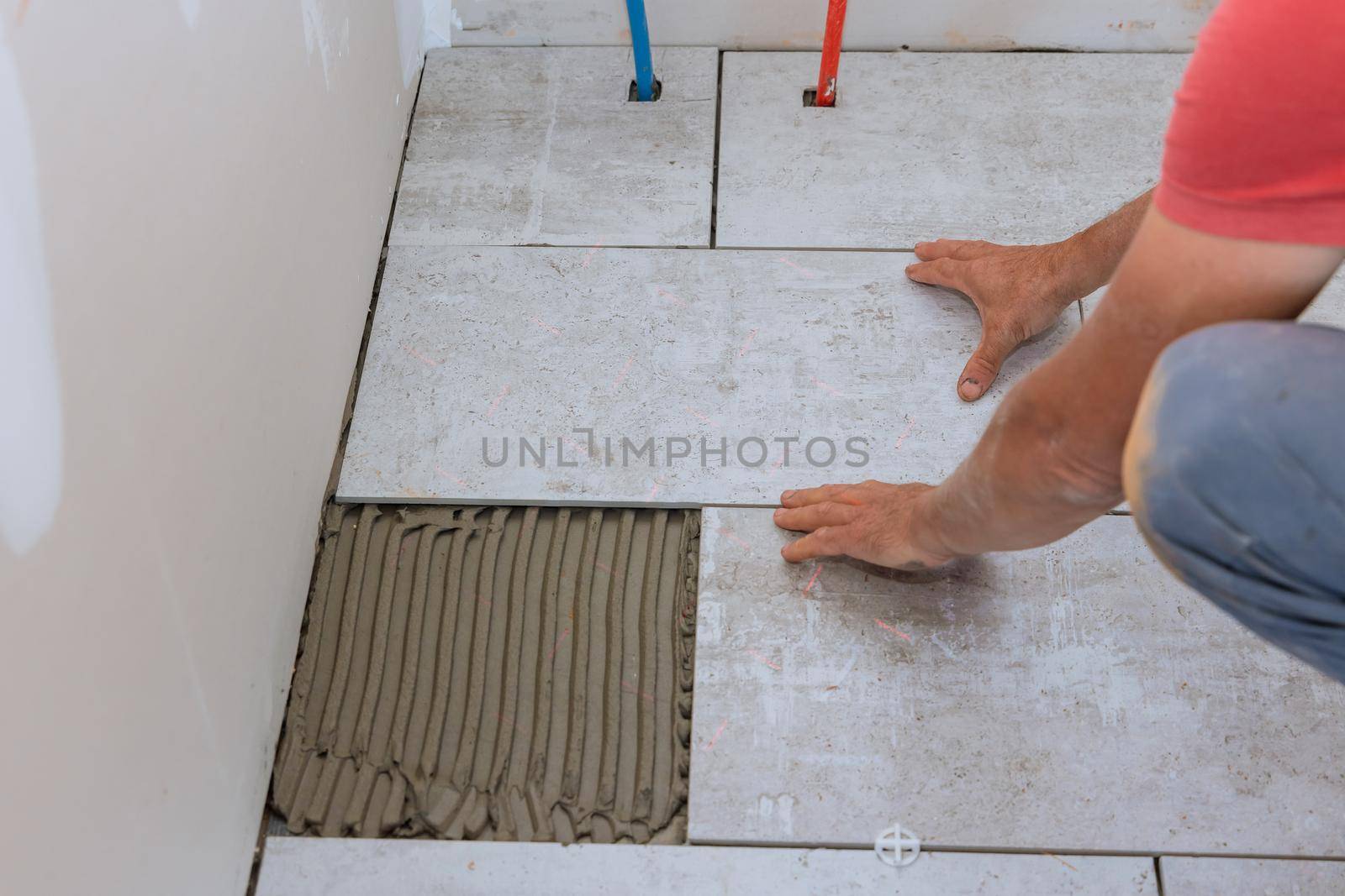 Floor ceramic tile installation on adhesive with home construction working