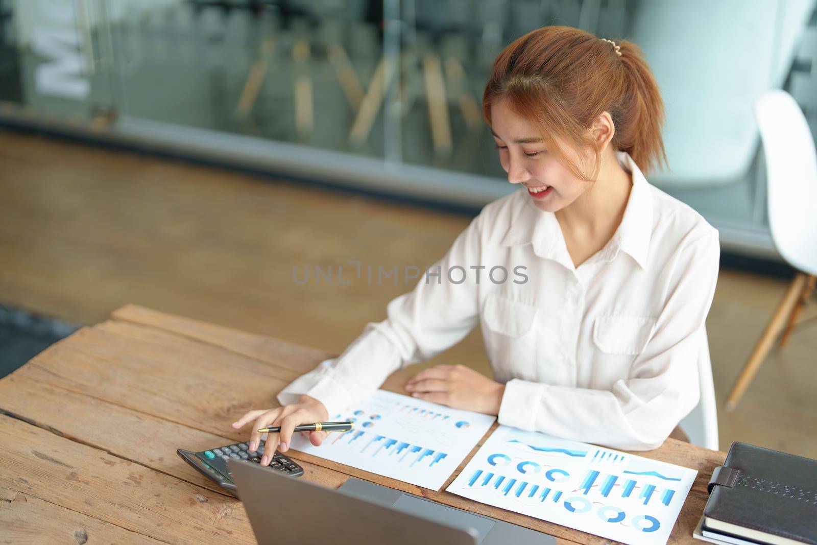 data analysis, marketing, accounting, auditing, portrait of business woman using marketing planning calculator using statistical data sheet, computer to present a marketing plan project at a meeting. by Manastrong