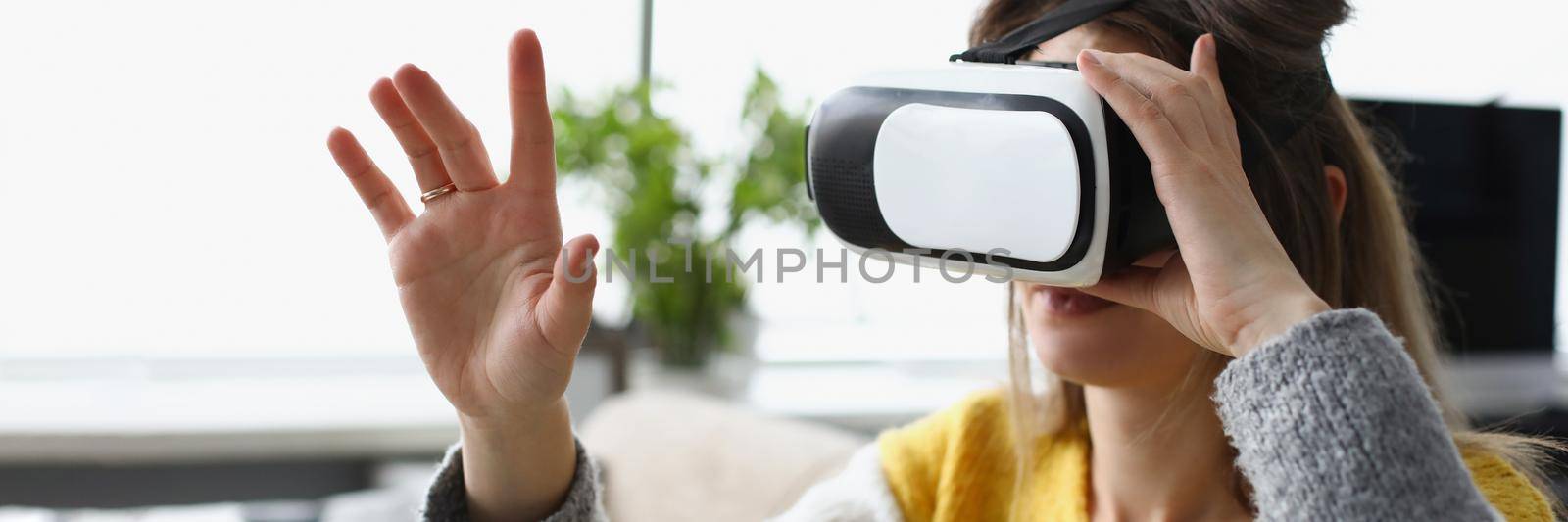 Close-up of young woman experiencing vr modern device at home. Dive into visual effects, fun pastime, adventure time. Modern technology, innovation, entertainment concept