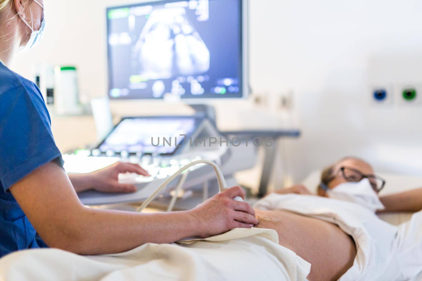 Close up of a pregnant woman having ultrasound scanning at the medical clinic. Healthcare and medicine concept.