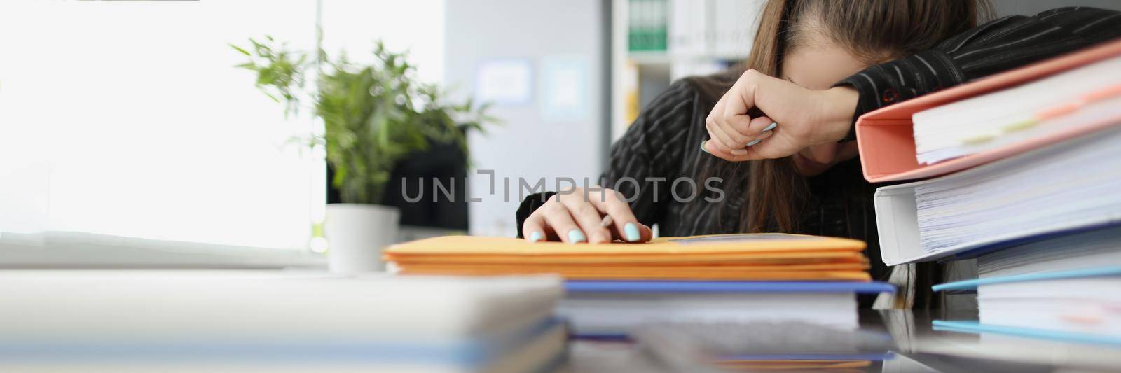 Close-up of tired overworked woman sleeping on workplace. Stressful and exhausted clerk in office, lots of stack with documents on desk. Hardworker, businesswoman, job concept
