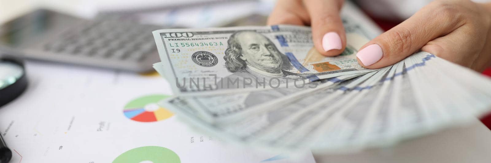 Bank worker hold stack of green papers by kuprevich