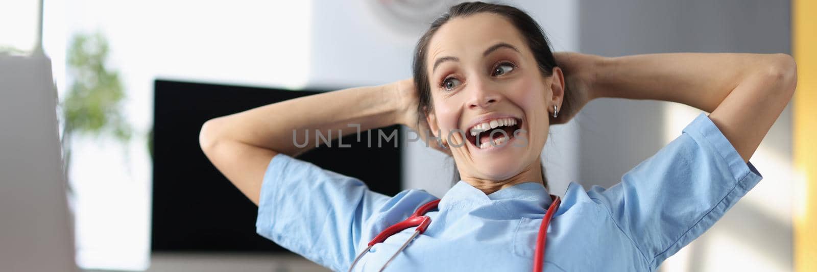 Portrait of laughing medical worker on break, doctor watch video on laptop, free time, qualified female in office. Medicine, healthcare, clinic, lunch, spare time, fun concept