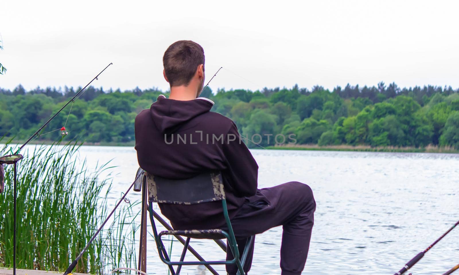 Close-up of a fishing rod wheel, a man is fishing. Nature. selective focus