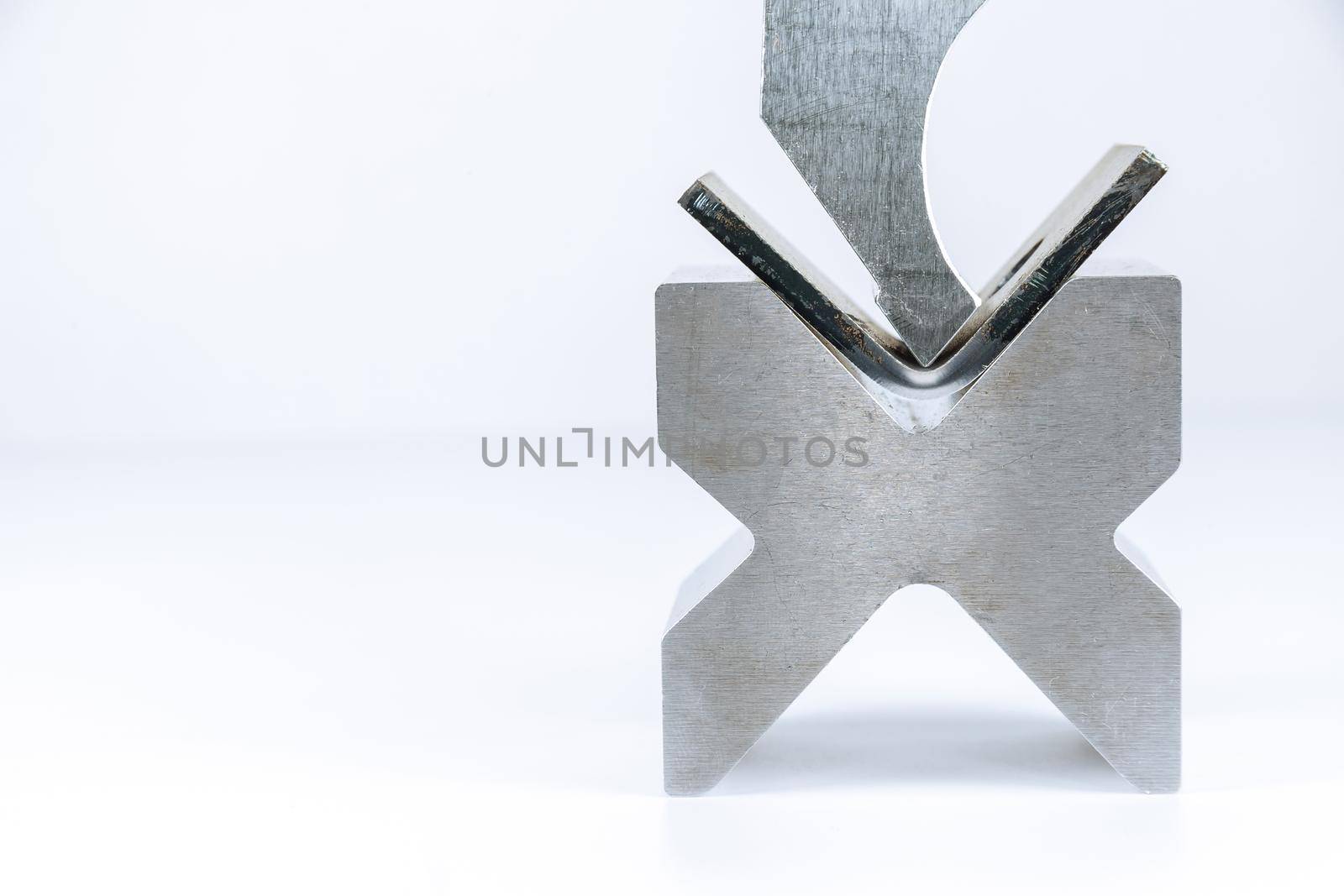 Sheet metal bending tool and equipment isolated on a white background. Bend tools, press brake punch and die. Bending tool isolated on a white background. Close up.