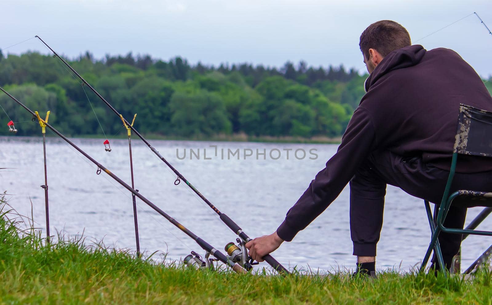 Close-up of a fishing rod wheel, a man is fishing. Nature. selective focus