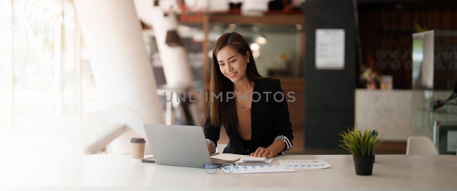 Portrait asian business woman working on laptop computer and calculator for financial. business accounting concept.