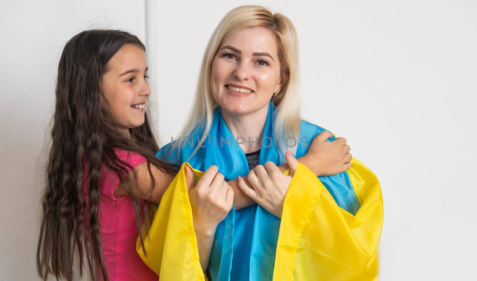 mother and daughter with ukraine flag. Pray for Ukraine.