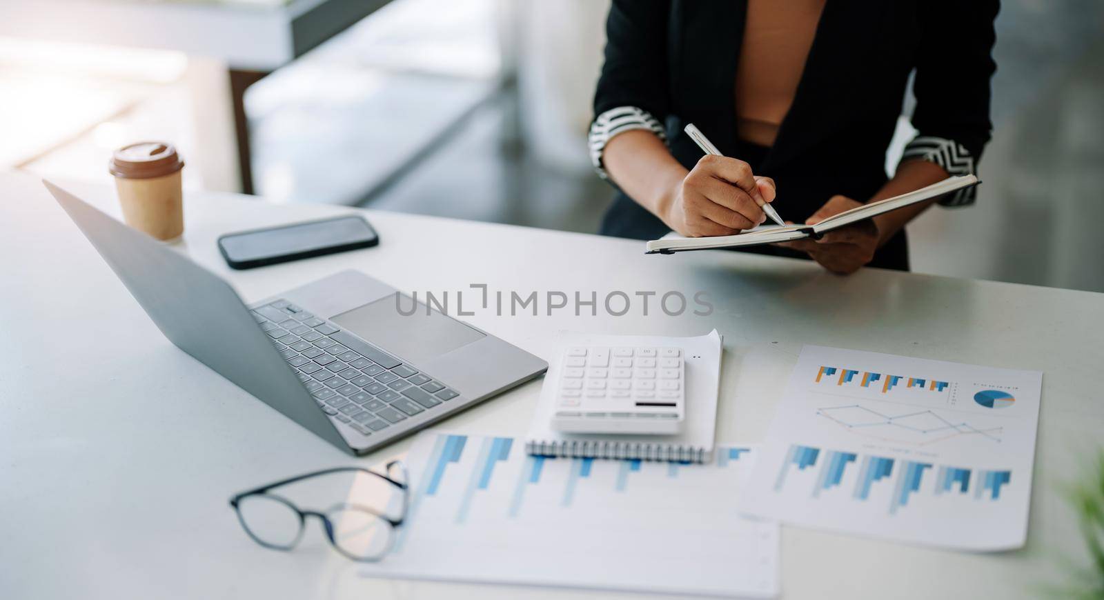 Closes up accountant asian woman hand is writing on notepad with pen in office. business accounting concept