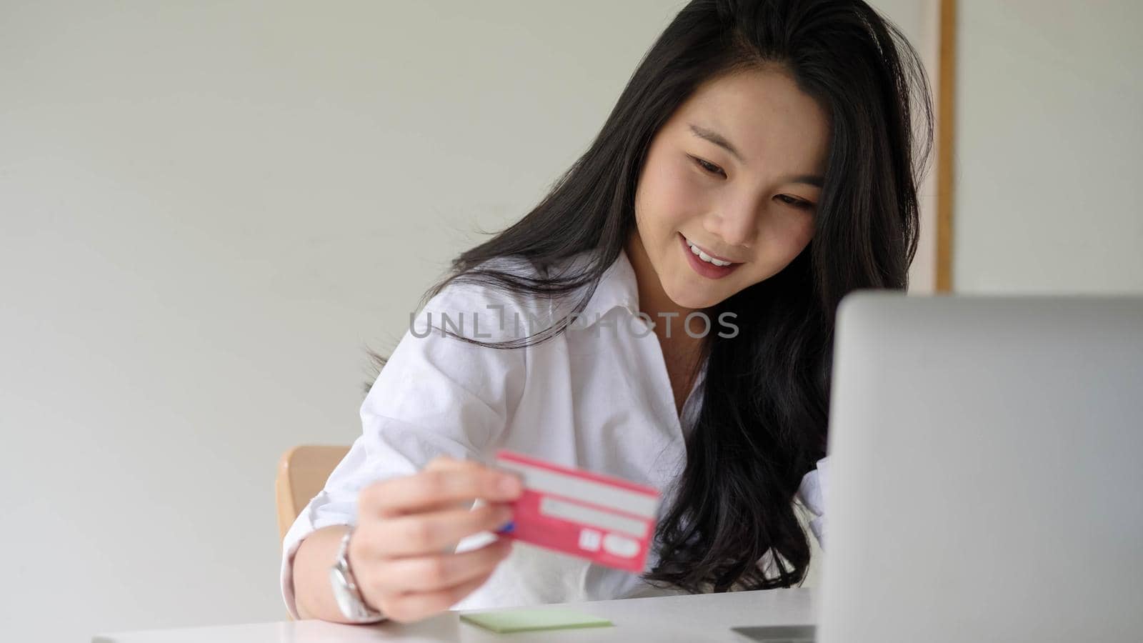 Close up woman using credit card for purchasing and shopping online on laptop computer.
