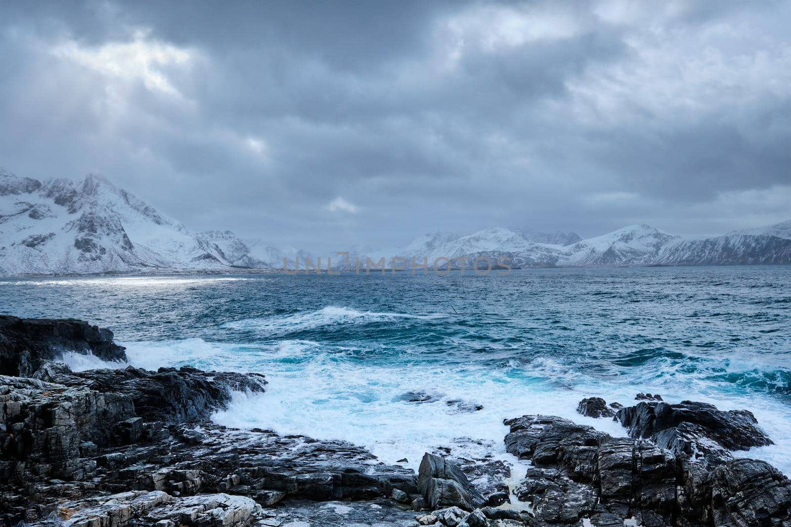 Waves of Norwegian sea crushing at rocky coast in fjord. Vikten, Lofoten islands, Norway