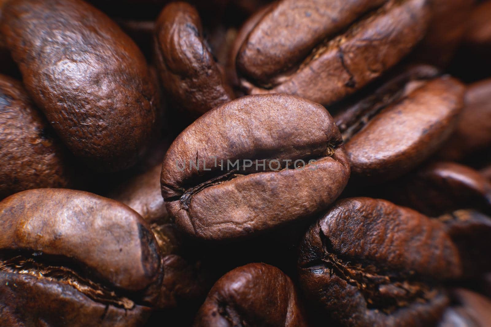 Close up extreme macro group of roasted brown or black coffee beans background in shallow depth of field. Enchanting coffee aroma by yanik88
