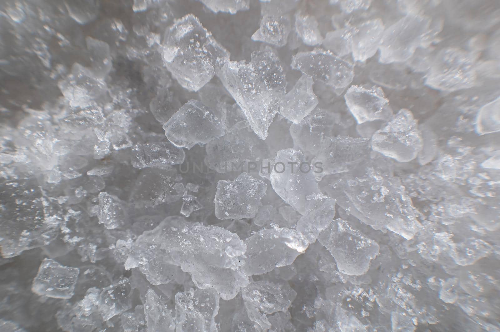 Coarse white iodized salt. Detailed background texture Macro close-up. Salt crystals of different sizes.