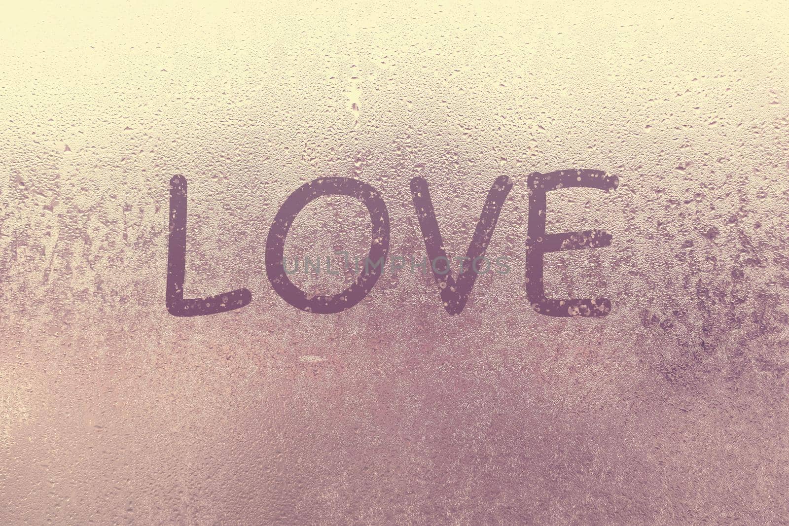 Word Love and shape of heart are drawn with a finger on fogged window glass. Valentine's Day, Valentine card creative. Blur Love sign drawing, blurred background. February its month love, concept