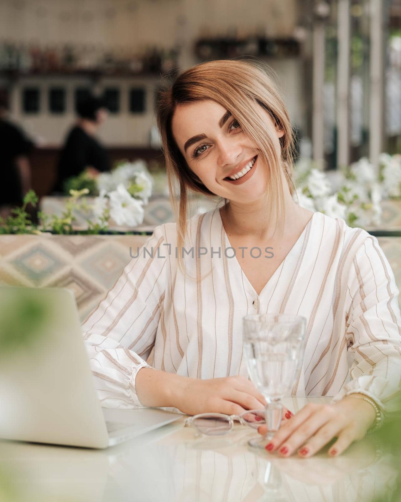 Cheerful Young Woman Smiling Straight Into the Camera, Female Working on Laptop While Having Lunch in Restaurant