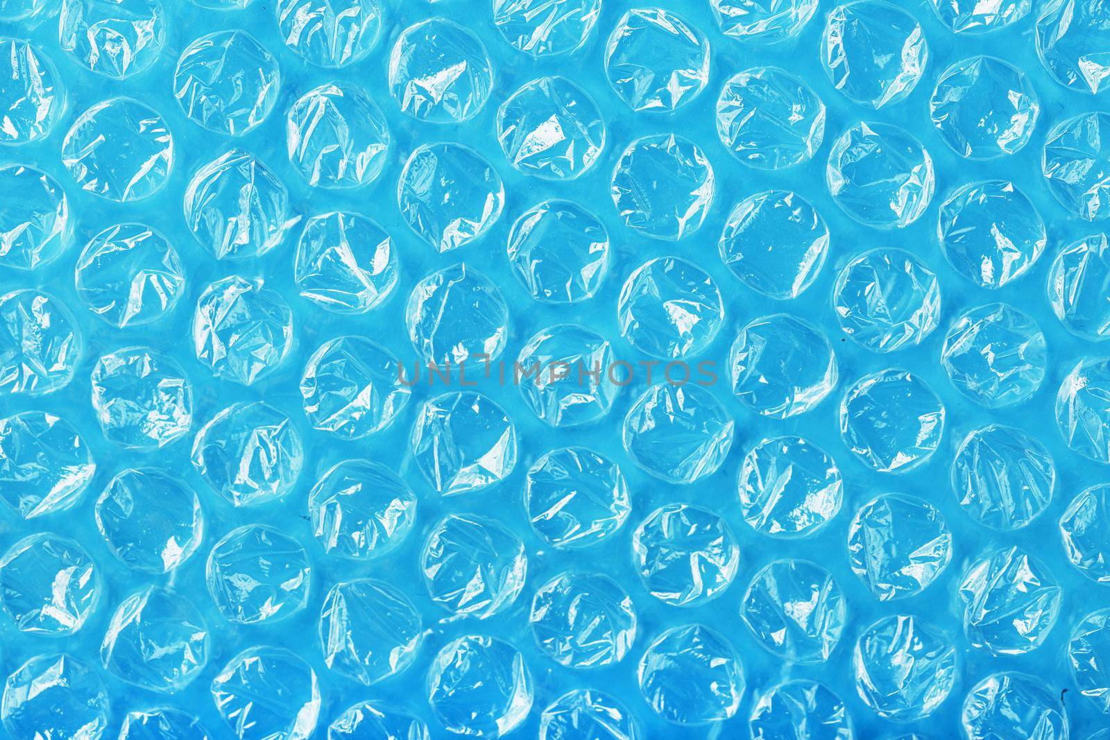 The texture of the packaging air-bubble film on a blue background in full screen