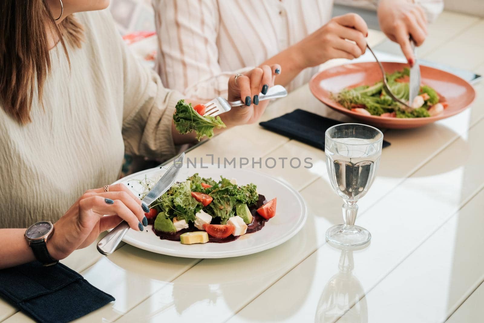 Close Up of Unrecognisable Women Having Lunch Meeting, Eating Salad in the Restaurant by Romvy