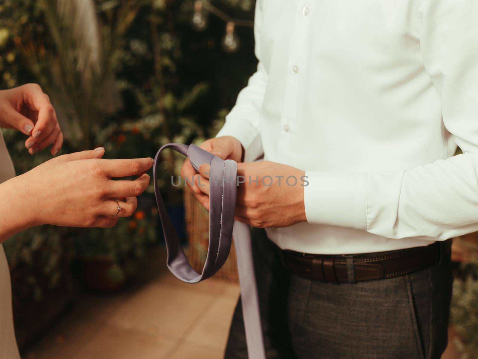 bride helps groom to wear a tie grain effect by Symonenko