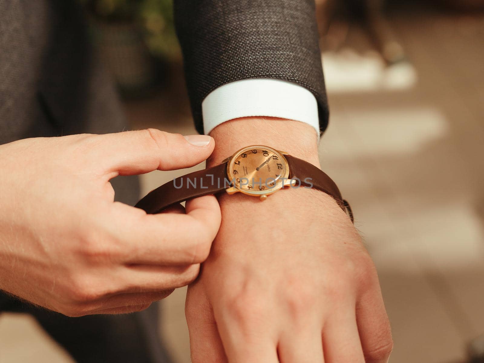 Businessman wearing the wristwatch. Grain effect. sunny