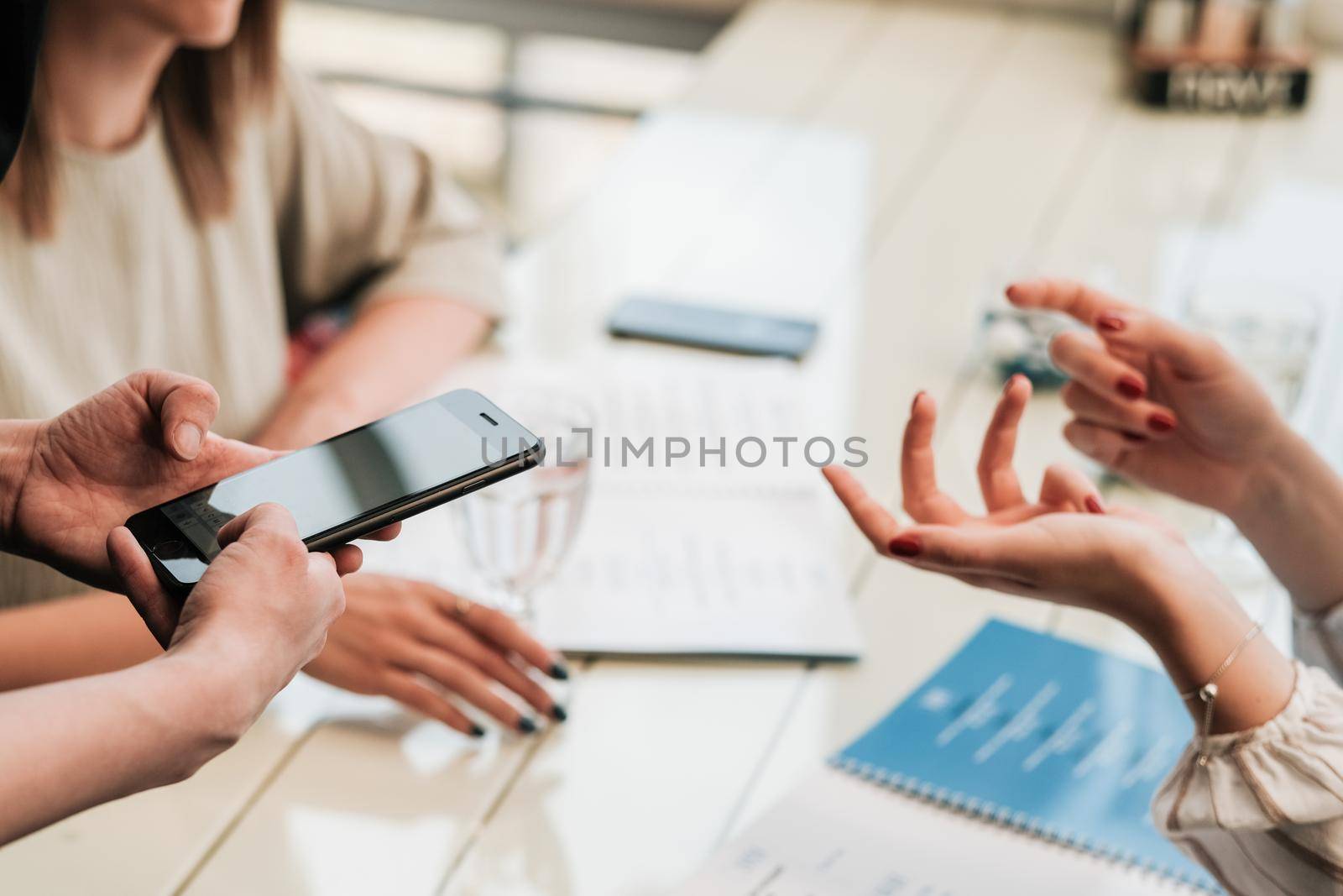 Close Up of Female Hands at Table, Two Women Making Order to Waiter with Smartphone in Restaurant