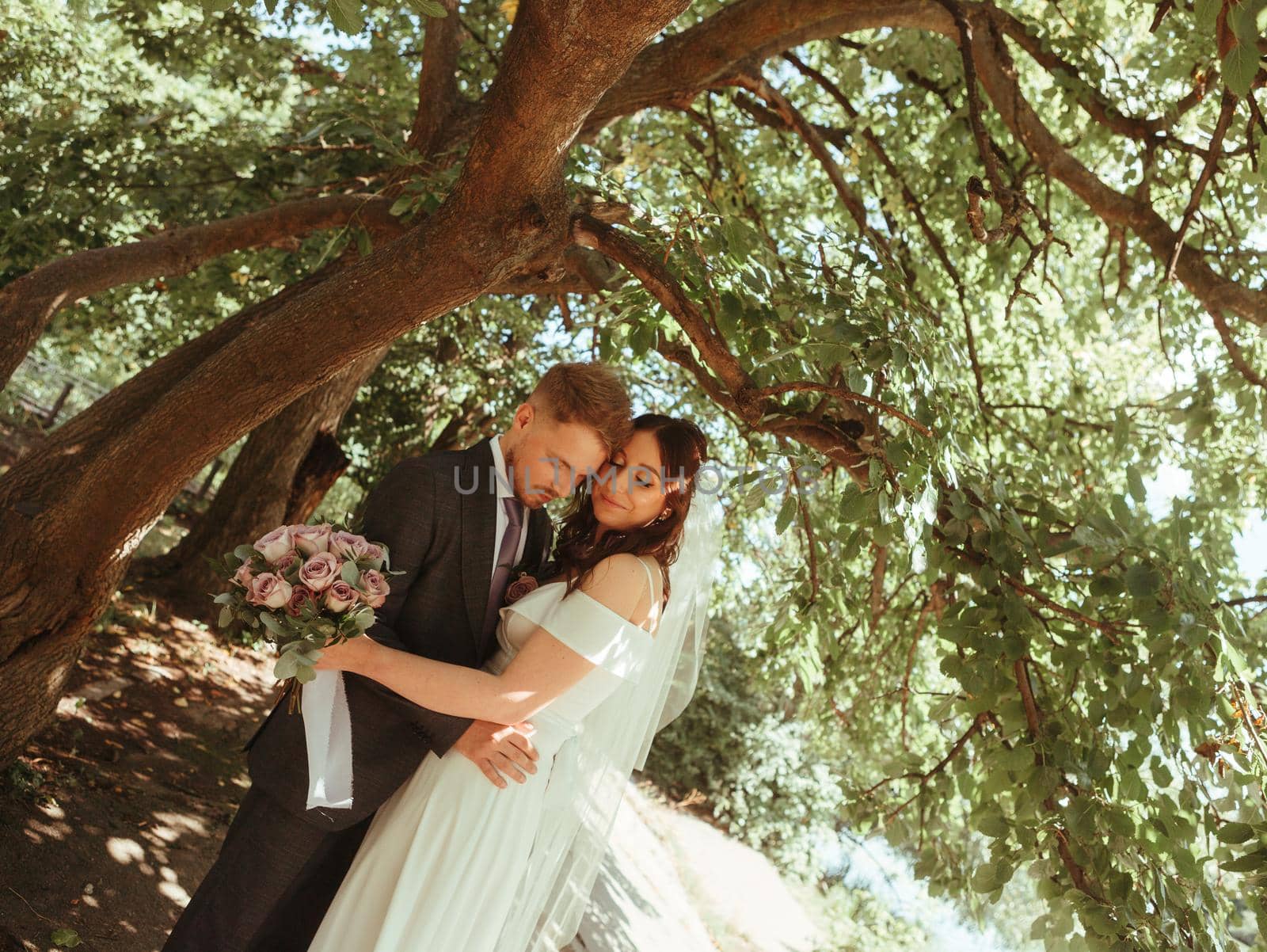Happy wedding couple walking in a botanical park grain effect authentic by Symonenko