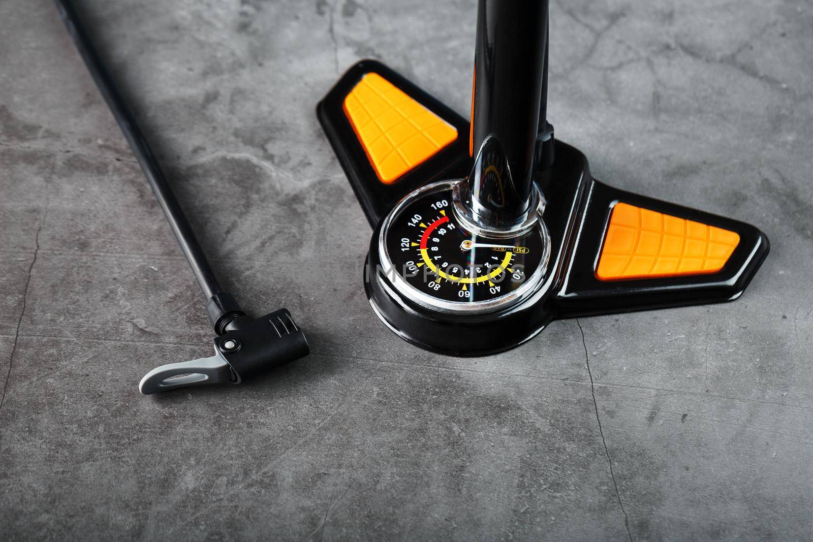 Air pump with a manometer and a wheel inflation hose on a dark background with free space