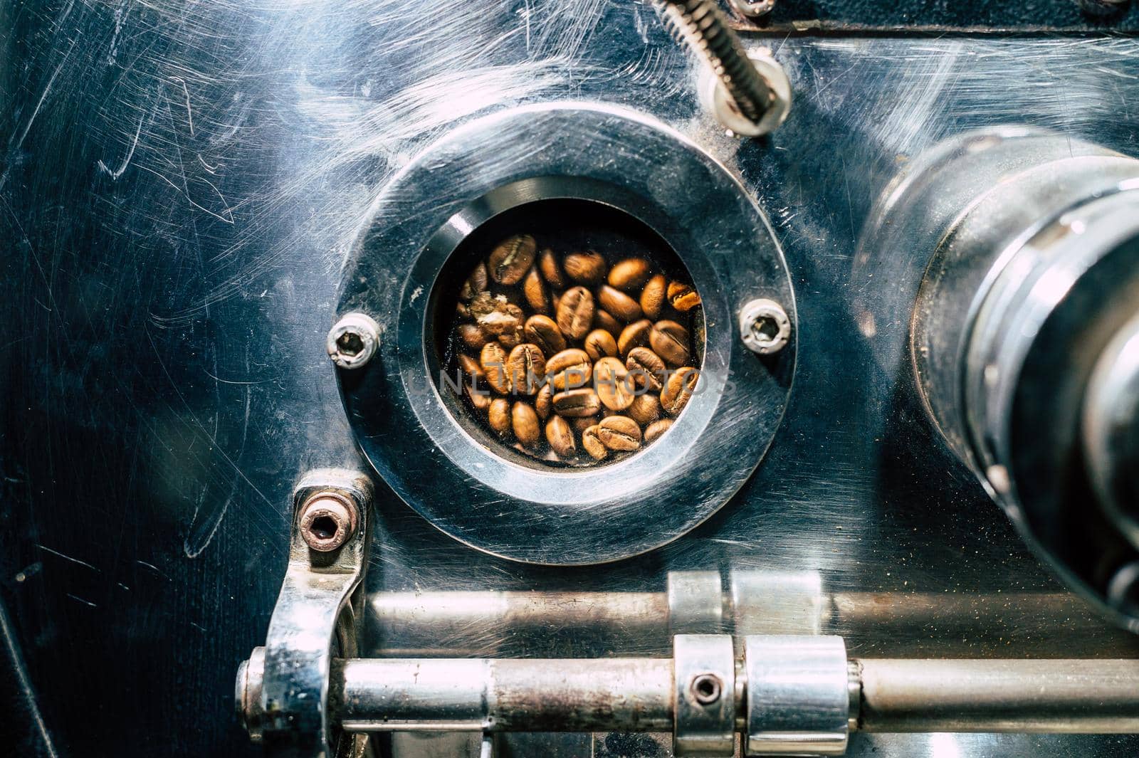 Coffee beans rotate in a coffee bean roasting machine. by Peruphotoart